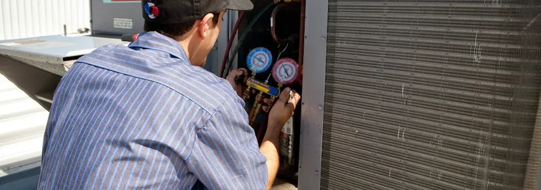 HVAC technician servicing a condenser unit in Bellingham